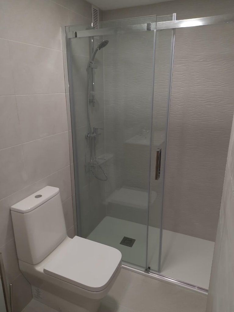 Ducha con mampara corredera y alicatado texturizado