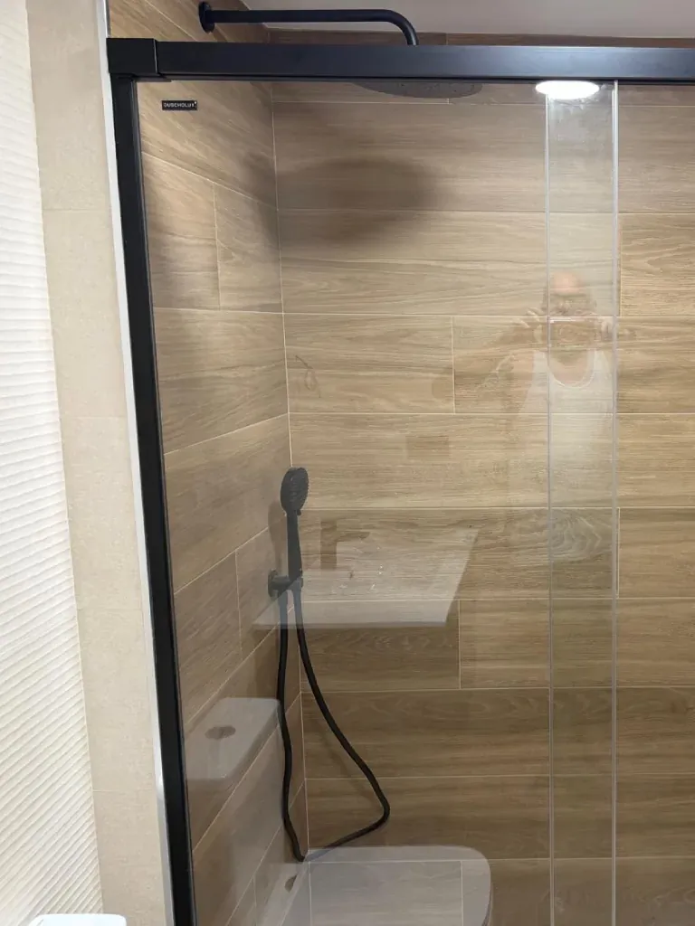 Ducha en piedra gris con toallero y mueble lavabo