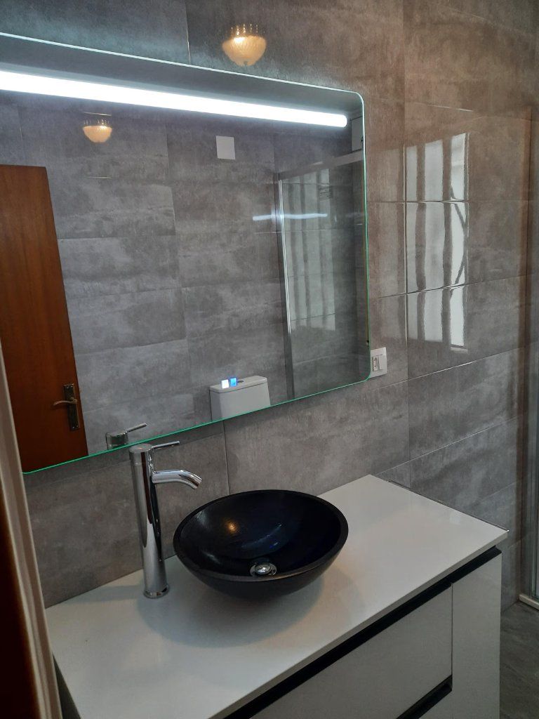Baño con lavabo sobre encimera y espejo LED