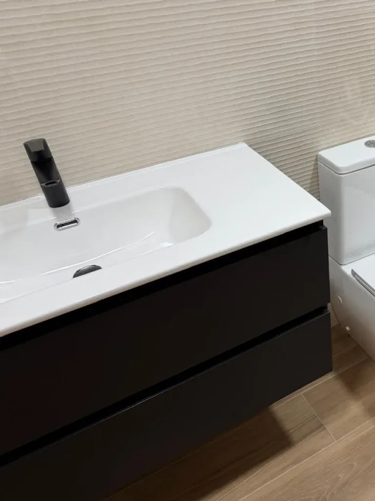 Detalle de mueble de lavabo con encimera y grifería negra