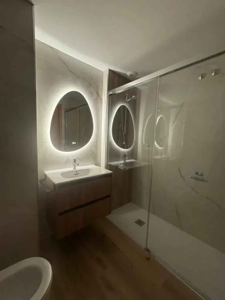 Ducha con espejos redondos iluminados y mampara