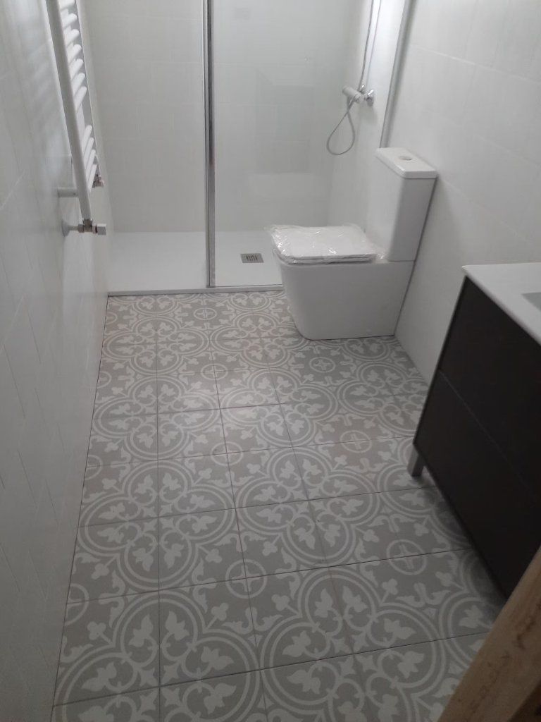 Ducha con alicatado gris y mueble de lavabo en madera